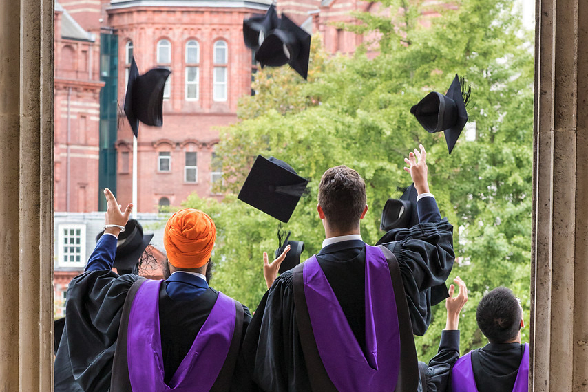 Students throw their mortarboards in the air during UCL graduations in 2017.